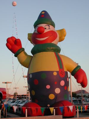 Giant clown sells used trucks.
