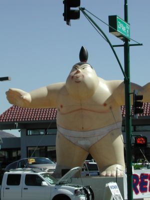Giant oriental wrestler sells Nissans.
